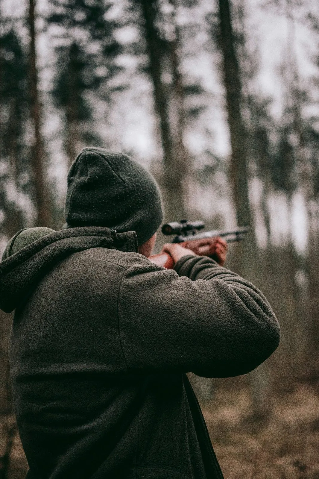 Hunter in camouflage tactical apparel in a forest environment